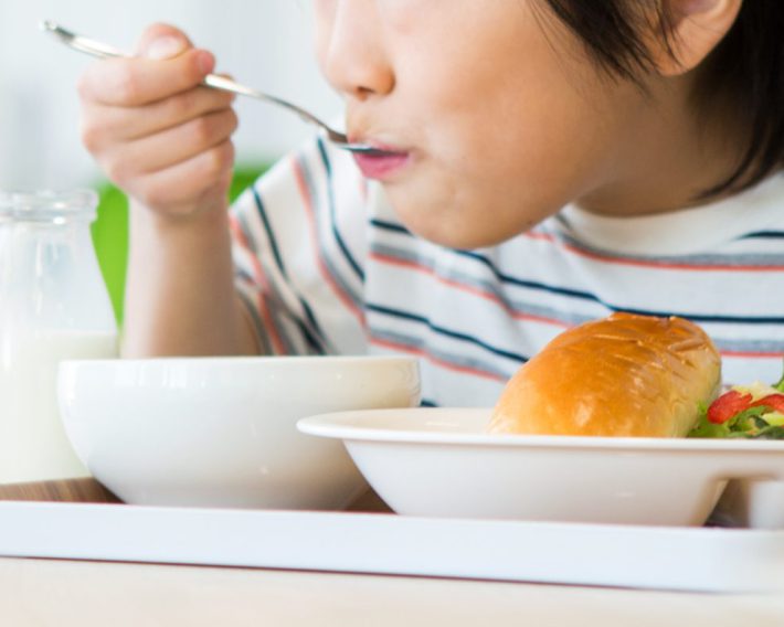 給食を食べる小学生