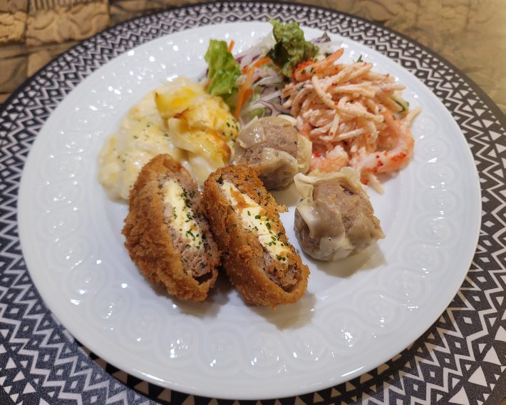 カット済ミックス野菜のサラダ、エビのマカロニグラタン、チーズ入りメンチカツ、肉シュウマイ、たらこスパゲッティサラダを並べただけのワンプレートごはん