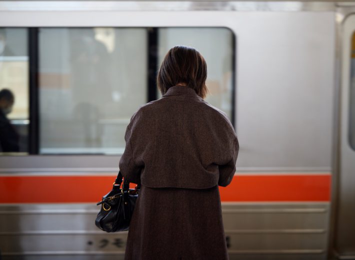 電車を待つ女性の後ろ姿