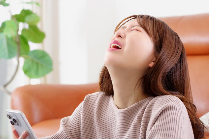 スマホを見て険しい表情をする女性