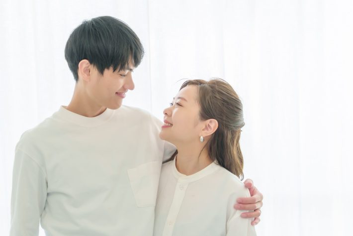 肩を抱いて微笑み合うカップル