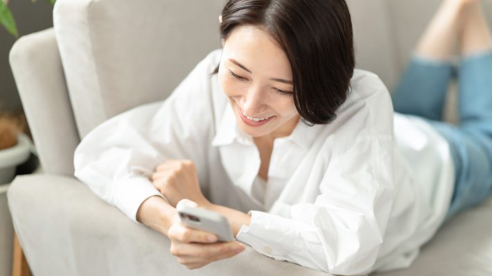 笑顔でスマホを操作する女性