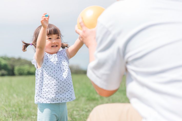 公園でボール遊びする大人と子ども