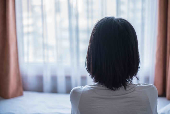 窓から眺める女性