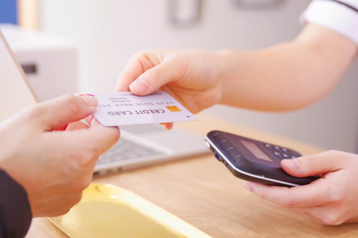 クレジットカードで支払いをする女性