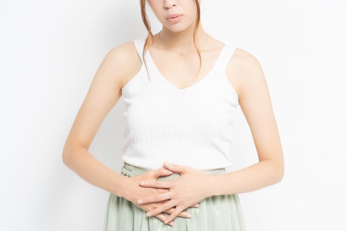 お腹に手をあてる女性