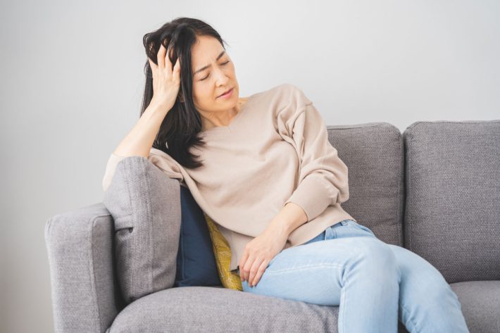 頭を押さえる女性