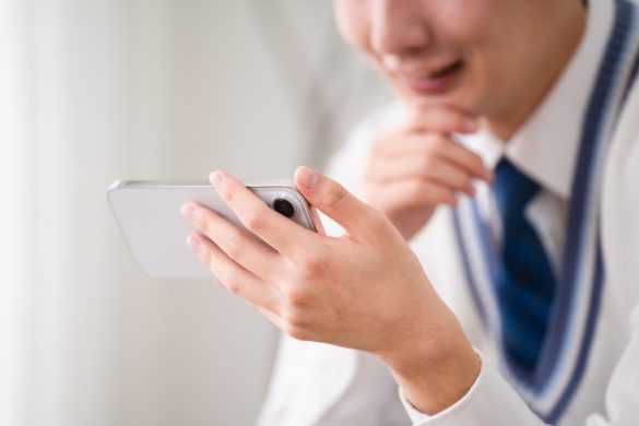 スマホを見る制服の男の子