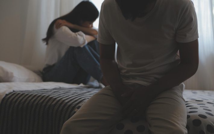 寝室で背を向けている男女