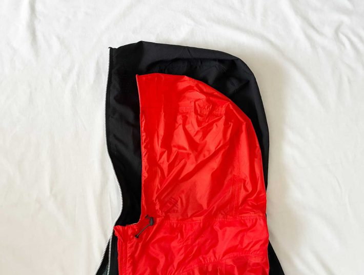 エックスシェルター暑熱フーディーのフード（写真黒色）に一般的なパーカーのフード（写真赤色）を重ねてみると大きさの違いが明らか