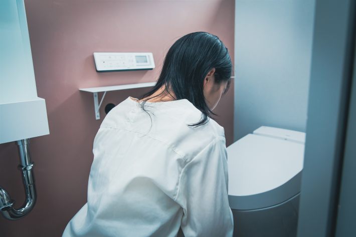 トイレでうずくまる女性