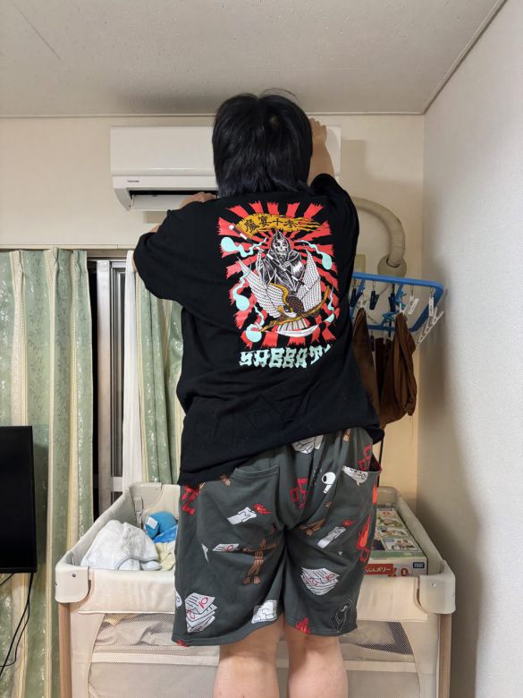 エアコンの掃除をする夫