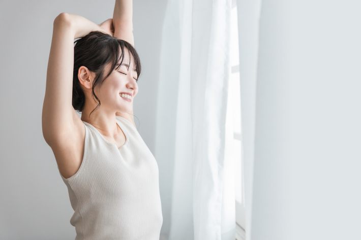 朝に背伸びをする女性