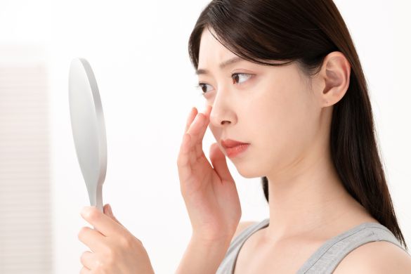 鏡を見て悩む女性